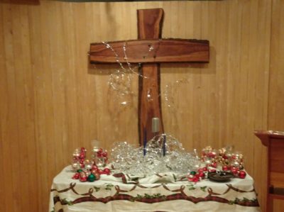 The Christmastide altar with tinsel stars, and many, many candles and red and gold ornaments